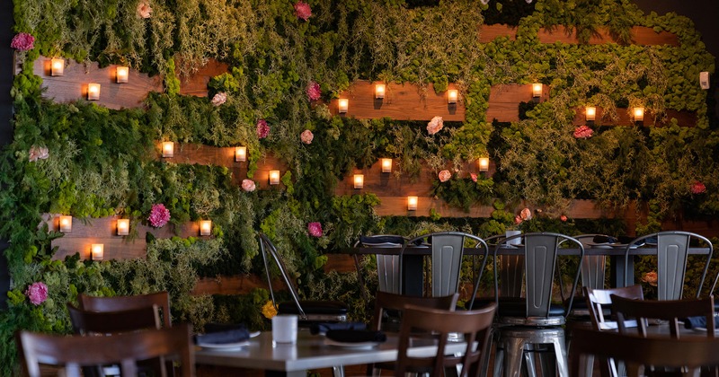 Interior, seating area, a wall with greenery, flowers and candles