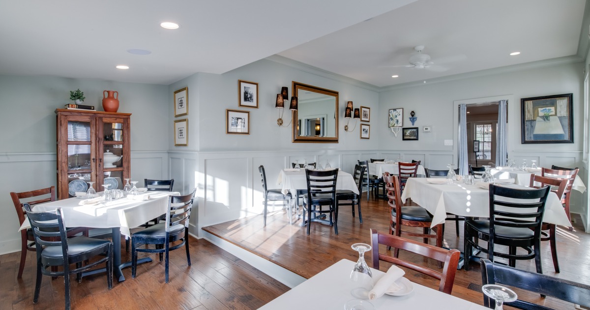 Interior, dining tables ready to receive guests, wall decor
