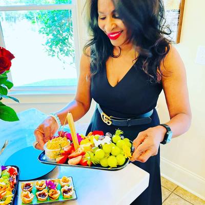 Woman holding a tray of fruit salad.