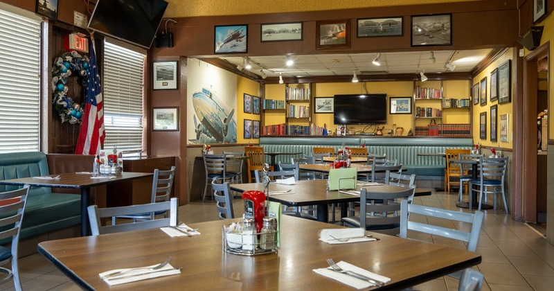 Interior of cozy dining area with dining tables ready for guests