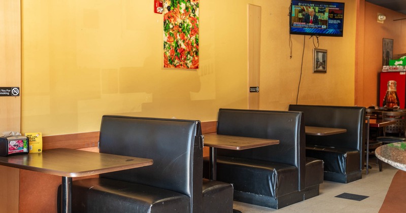 Interior, dining area, seating booths with tables, TV on the wall, tile flooring