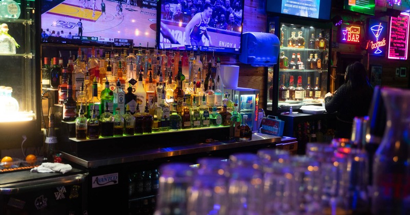 Bar, drink rack behind, TV's above