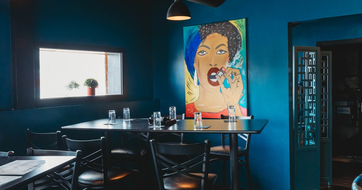 Interior, high seating area, high tables with stools, large format painting on the wall