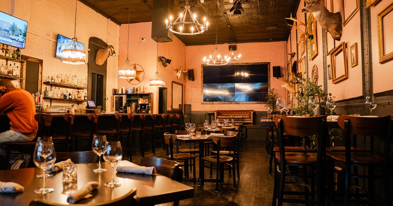 Modern rustic-style restaurant interior dining area with set tables and bar