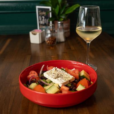 Greek salad topped with seasoned feta cheese, paired with white wine.