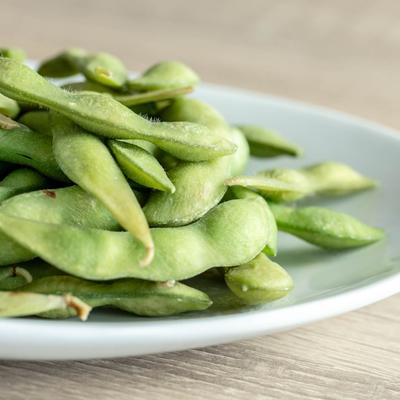 Edamame served on a white plate, close up.