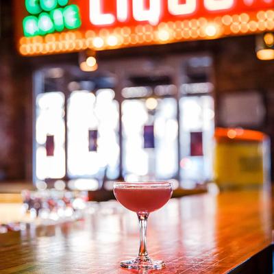 Pink cocktail on a bar.