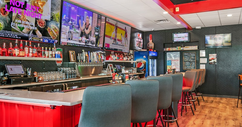 Bar area, upholstered bar stools, TV sets above the bar