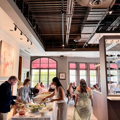 Interior featuring a buffet setup, vaulted ceiling and and a wine display wall.