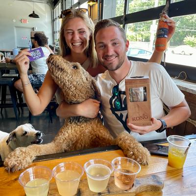 Customers and dog posing at table.