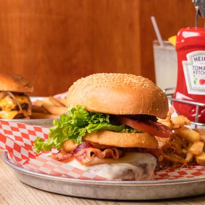 Bacon cheeseburger with onion ring and fries.
