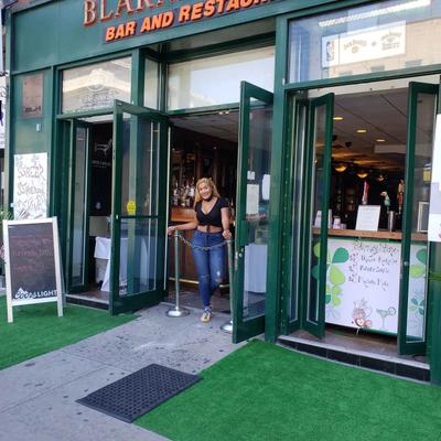 A person standing at the entrance of Blarney Stone restaurant and bar.
