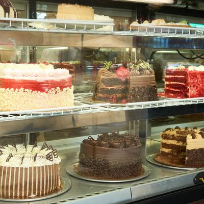 Various cakes in a glass display case.