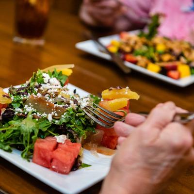 Fresh fruit and greens salad with feta and citrus slices.