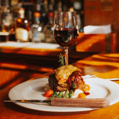 Gourmet dish and a glass of red wine on the bar counter.