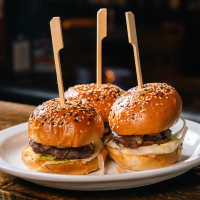Three beef sliders on seeded buns.