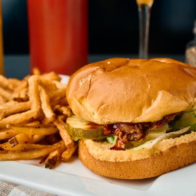 Smash burger with pickles and lettuce, served with fries.
