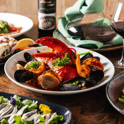 Seafood pasta surrounded by assorted dish plates.