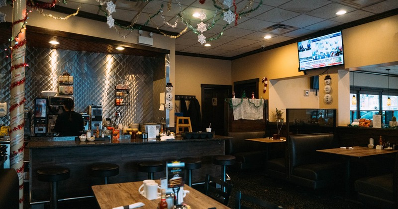 Interior, a bar on the left, booths with tables and chairs on the right