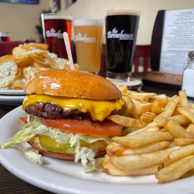 Brewhouse Cheeseburger with fries beers in background.