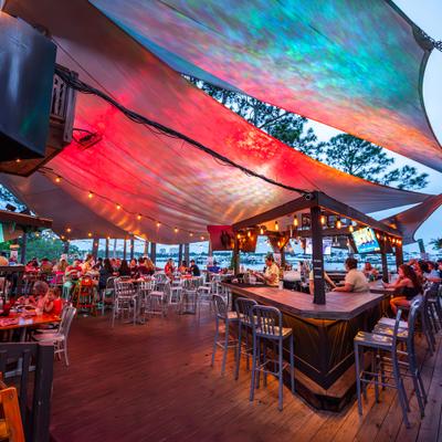 Outdoor patio covered with awnings featuring counter and table seating.