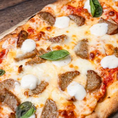 Pizza with sausage, mozzarella, ricotta, and basil