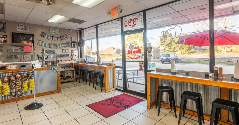 Interior, entrance, bar tables and stools by windows