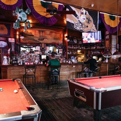 Interior, pool tables in the bar area, seated guests at the bar