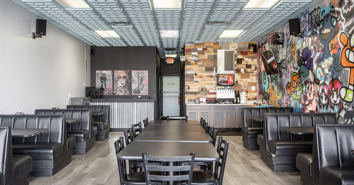 Interior seating area with a long table at the center and booths along the walls on both sides