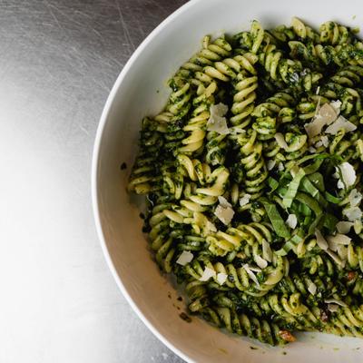 Pesto fusilli pasta topped with Parmesan.