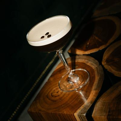 Elegant cocktail glass on a wooden surface holding an espresso martini.