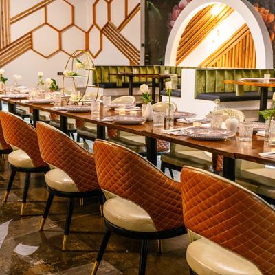 Interior featuring upholstered quilted dining chairs and archway design elements.
