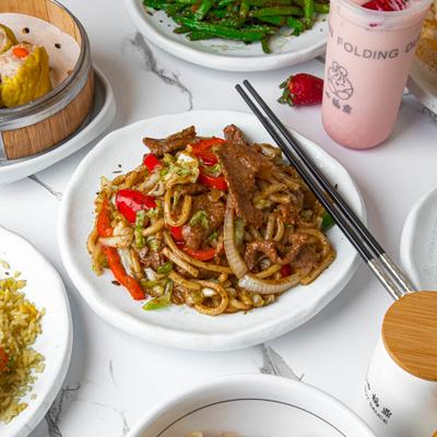 Beef Fried Udon served on the table with other dishes.