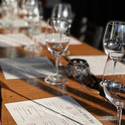 A closeup of a table with clean wine glasses and menus in the sunlight