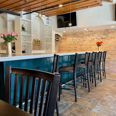 Warm, inviting bar interior with teal paneling and brown barstools.