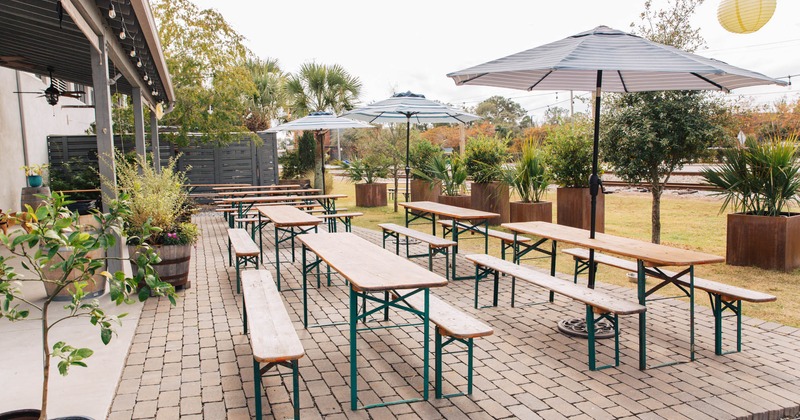 Patio, tables and benches with parasols and plants