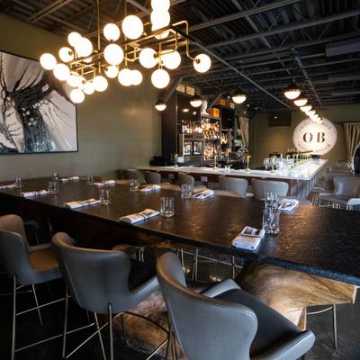 Interior featuring a long wooden communal table and globe-cluster chandelier lighting.