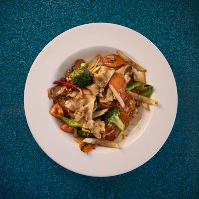 Plate of Drunken noodles featuring various vegetables, overhead view.