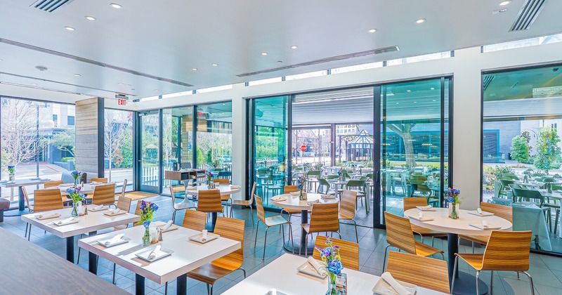 Modern and cozy interior dining area with set tables, view on the patio