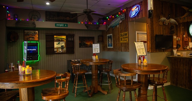Cozy interior seating area with wooden round high tables and stools