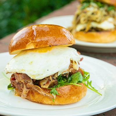 Sandwich with egg, smoked brisket, cheese, arugula, and caramelized onion aioli.
