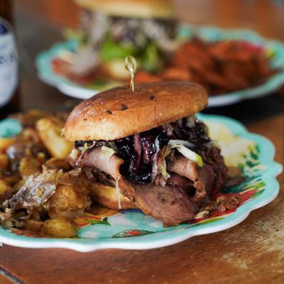 Smoked Brisket Sandwich sandwich with blackberry-chipotle sauce, served with seasoned potatoes.