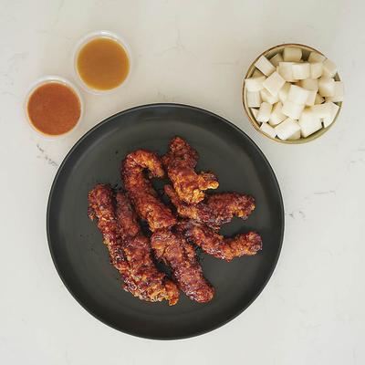 Photo of Gangnam Spice chicken tenders and a side of pickled radish and Gochu-mayo dips.