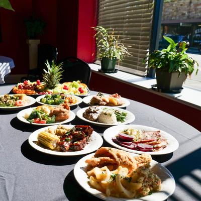Variety of food items sereved on a table next to a window.