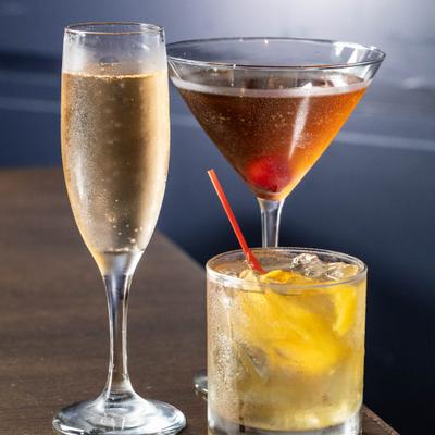 Mimosa, Old Fashioned, and Manhattan rest on a table.