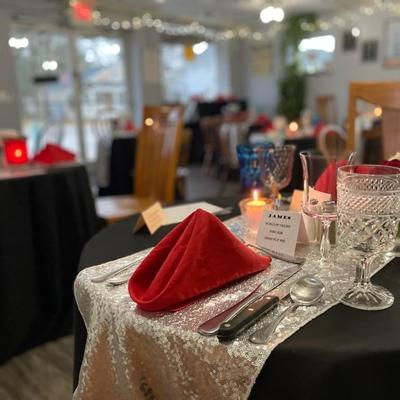 Elegant dining setup featuring a red napkin, crystal glassware, and candles.