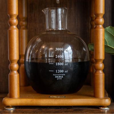 Cold brew coffee in a glass container marked with measurement lines'.