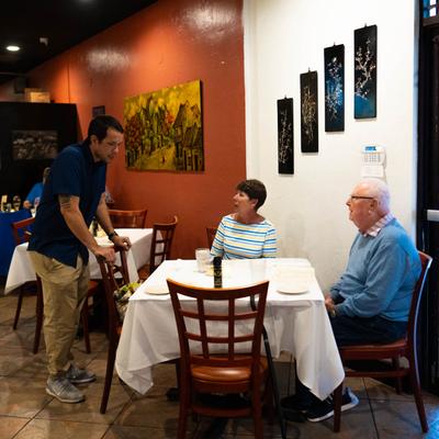 Interior, dining area, employee taking an order from customers.