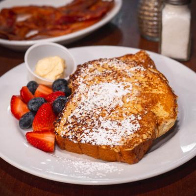 French toast dusted with powdered sugar, served with fresh berries and maple butter.