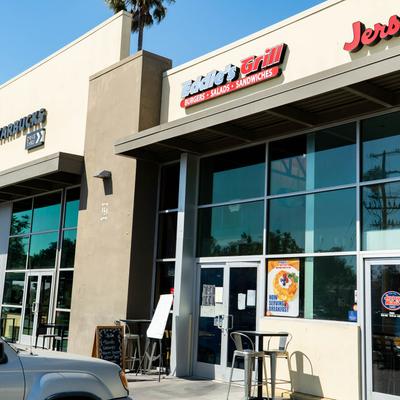 Exterior of Eddie’s Grill with glass windows and outdoor seating.